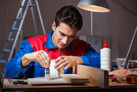 在DIY概念中 年轻人将木块混在一起密封剂工人维修修理工建设者男人地板木头木工房子图片