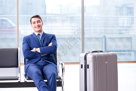 商务人士在机场等着他的飞机 在商业圈里等他男人手提箱商务假期游客大厅套装飞行微笑乘客图片