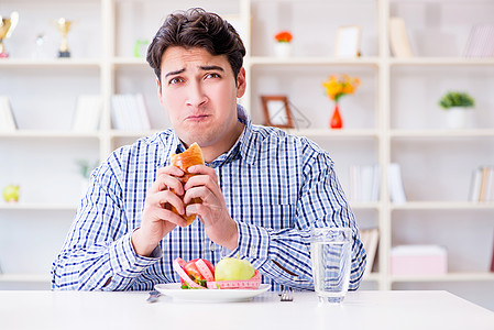人类在饮食中有健康食物和面包的两难境地午餐烹饪困境盘子蔬菜餐厅营养排毒热狗挫折图片