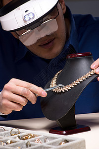 晚上深夜在车间工作的珠宝商工匠首饰戒指手镯玻璃估价师典当商维修男人镊子图片
