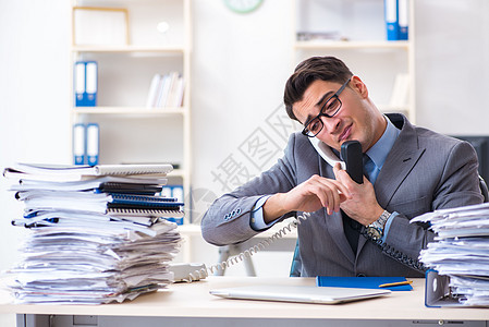 绝望的伤感雇员在呼叫中心的办公桌里疲惫不堪压力电脑桌子文书男人商务电话报告办公室讨论背景图片