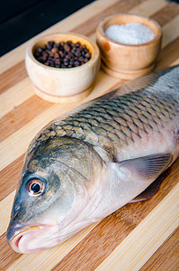 在饭食准备概念中 未烹煮的鱼在切菜板上厨房鱼片午餐香菜柠檬烹饪木头鳟鱼饮食胡椒图片