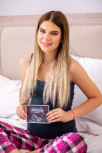 在床上的年轻快乐的孕妇妈妈枕头扫描幸福卧室女性婴儿生育力腹部产妇图片