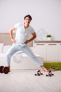 年轻人在卧室做晨间例行活动房子睡衣运动员体操娱乐哑铃饮食练习健身房健美图片