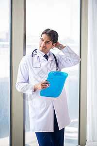 年轻英俊的医生站在窗边助手外科职业药品治疗临床男人实验室医院记录图片