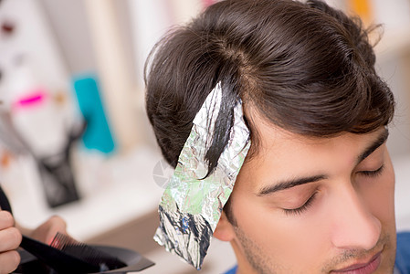 年青男子看女理发师造型客户男性深色刷子护理锡纸染色金属梳子图片