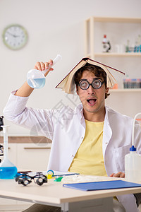 做实验和测试的有趣的疯狂化学家科学家显微镜发明者混合物烧瓶医生玻璃物质学生男人图片