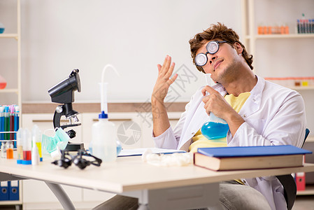 做实验和测试的有趣的疯狂化学家享受科学眼镜化学医生烧杯学习实验室教授显微镜图片