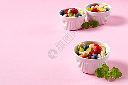 一碗健康的新鲜水果沙拉 在粉红色背景上 顶级视图复制空间饮食美食菜肴小吃奇异果浆果午餐作品早餐海鲜图片