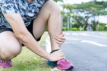 亚裔男子在公园的路上跑时用手握着脚踝 因锻炼概念而受伤运动员肌腱身体扭伤疼痛膝盖伤害运动韧带成人图片