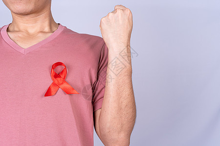 男人胸前的红色艾滋病意识丝带 举起手在灰色背景下与他们作斗争 世界艾滋病日 医疗保健和医疗概念世界生活团结活动插图基金疾病丝绸预图片