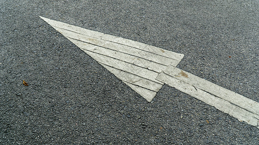 一辆灰色的铺面公路上的白色箭头画上标志 指向汽车应该驾驶的方向指示牌速度运输城市小路路面交通指导黑色地平线图片