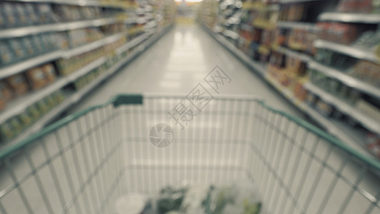 从 POV 提供的超市马车的模糊图像购物食物市场顾客购物中心店铺女士销售运动零售图片