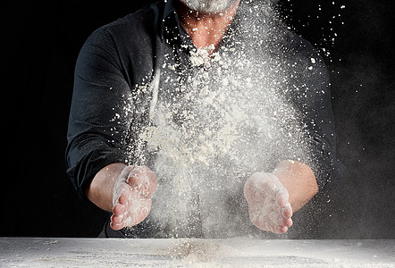 面粉手穿黑色制服的厨师喷洒白面粉d面团食物小麦美食灰尘桌子速度运动力量行动背景