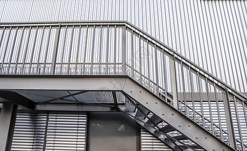 在现代建筑结构的金属楼层上 近距离观察蓝色运输走廊隧道办公室自动扶梯窗户天空城市石头图片