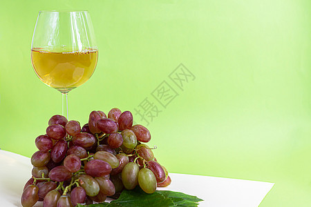 又大又轻的酿酒葡萄 它覆盖着一层叫做酵母的白色涂层 杯子里装满了清淡的酒 水滴在浆果上 在多色背景上水果收藏水壶发酵农场种子酒精图片