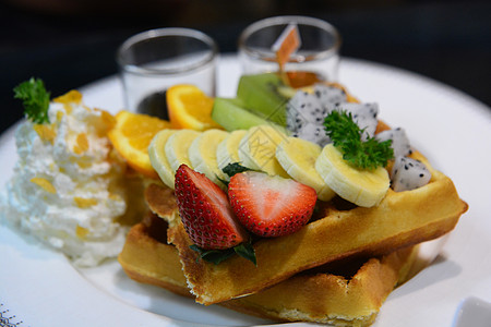 在白盘上混合水果和鞭奶油的松饼橙子浆果食物圣代自助餐美食蜜蜂奶制品营养甜点图片