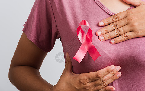 妇女穿着粉色T恤 她有粉色乳腺癌意识活动药品衬衫摄影肿瘤学裁剪乳腺疾病帮助丝带图片