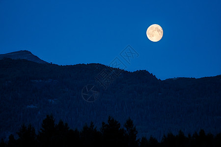 在满月的山上 暮光照耀天空岩石美丽黑色黄色森林月亮旅行辉光风景图片