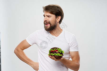 男人吃汉堡汉堡快餐饮食食品 食物摄入白T恤图片