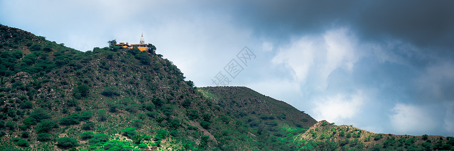 一座山上的印度教寺庙 塔楼和尖顶在远处清晰可见 背景是印度拉贾斯坦邦拍摄的黑暗季风云旅游历史天空城市地方目的地色彩佛教徒佛塔上帝图片