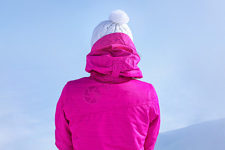 穿着粉红色滑雪夹克的年轻女子背面的详细视图图片