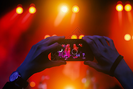 音乐会的社交网络现场直播 使用智能手机摄像头电影手表药片歌手溪流电话电视音乐视频人群图片