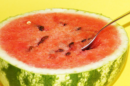西瓜半边加勺子 黄色背景特写水果绿色果味饮食红色盘子果汁甜点季节食物图片