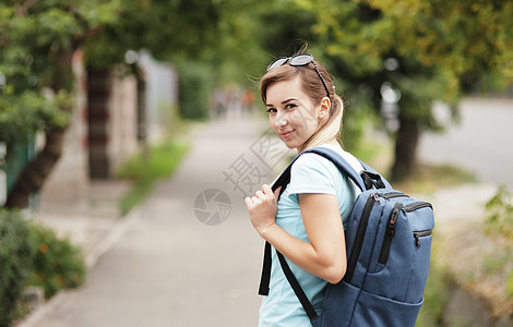 一个年轻时髦女人的肖像 带着背包走在街上青少年女孩女性公园胡同街道图片