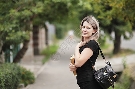 一个年轻时髦女人的肖像 带着背包走在街上胡同街道女孩青少年女性公园图片