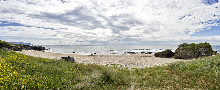 海滩上的岩石支撑海洋地平线脚印多云巨石花朵风景海岸海景图片