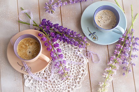粉红和紫色的花朵和咖啡 放在旧木制破烂桌子上图片
