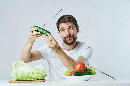 穿着白色T恤衫的男子蔬菜饮食和素食生活方式运动相机沙拉橙子微笑男性工作室男人食物桌子图片