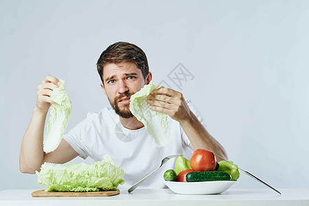 穿着白色T恤衫的男子蔬菜饮食和素食生活方式喜悦快乐冒充桌子微笑男性幸福香蕉工作室相机图片