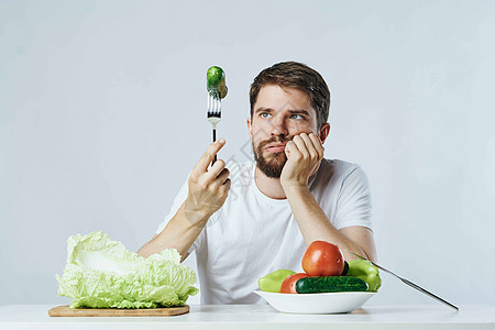 穿着白色T恤衫的男子蔬菜饮食和素食生活方式水果成人眼睛快乐幸福橙子男性运动桌子沙拉图片