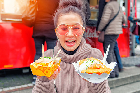 女孩在Ger吃法式薯条和鲑鱼街食物图片