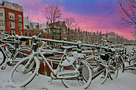 日落时荷兰下雪阿姆斯特丹的城市风景房子建筑街道首都建筑学城市历史自行车图片
