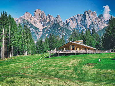 阿尔卑斯山美丽的木屋田园风光假期晴天山脉蓝色阳光场景山峰房子图片