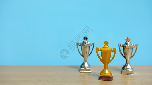 金奖杯 两银奖杯 在木制桌子上方胜利报酬团队蓝色数字商业冠军男性老板男人图片