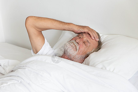 躺在床上睡着的老年退休男子感到担心压力枕头卧室长老失眠就寝时间说谎房间丈夫背景图片