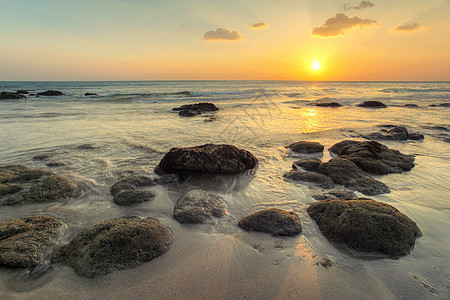 低潮期间金色日落光下的空沙滩上湿沙子图片