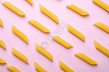 意大利意面 粉红背景的原薄面条通心粉黄色小麦粉色面团白色管子极简饮食美食营养图片