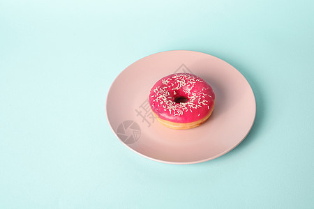 粉红色的甜甜圈 粉红色的盘子上洒着白色的糖 甜甜的釉面甜点蛋糕食物小吃面团美食早餐小雨营养饮食蓝色图片
