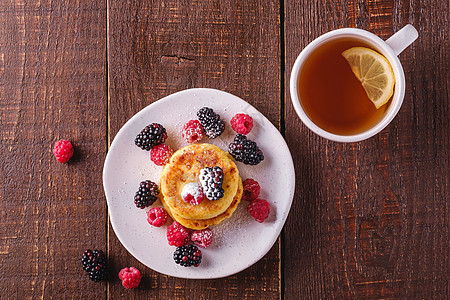 奶油芝士煎饼 卷心甜甜点和浆果油炸饮食油条水果覆盆子盘子杯子柠檬木头小屋图片