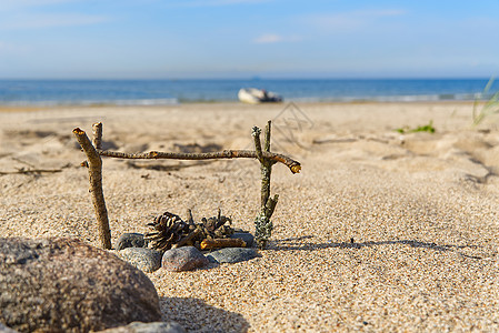 在夏日阳光明媚的阳光下 在黄海沙滩上的一个小型手工壁炉火焰旅行木头材料林地活力自然日志海滩营火图片