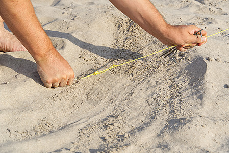 钉入沙子以将绳子拉出帐篷的金属钉 在沙滩上露营 人在沙滩上搭起了帐篷 自然旅游概念旗帜旅行配件桅杆远足游客绳索热带蓝色营地图片