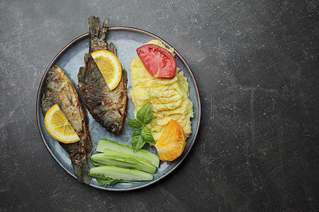 盘子上的炸鱼和蔬菜 水泥灰色柜台海鲜午餐食物黄瓜饭馆餐厅油炸桌子沙拉用餐图片