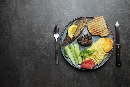 炸鱼 肉牛排和盘子上的蔬菜 水泥灰色柜台背景营养午餐饭馆用餐桌子面包油炸牛扒炙烤图片