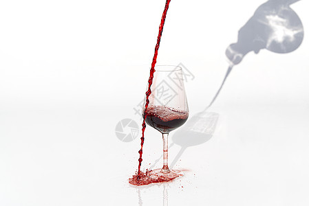 Sommelier在白色背景上倒红葡萄酒 将红葡萄酒洒到白桌上的玻璃杯上美食倾析液体饮料奢华地窖食物侍酒师酒精阴影图片