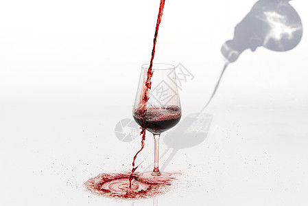 Sommelier在白色背景上倒红葡萄酒 将红葡萄酒洒到白桌上的玻璃杯上食物瓶子庆典侍酒师红宝石倾析酒厂液体地窖水晶图片